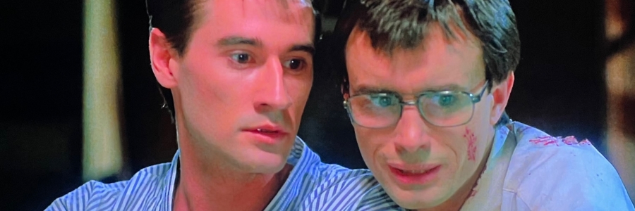 Two men look aghast at something out of sight.