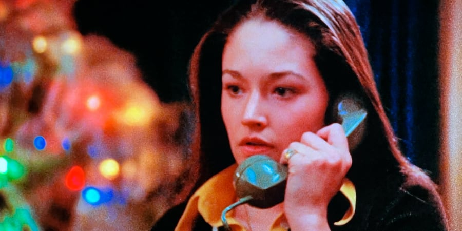 A woman is on the phone listening to a dangerous crank caller.