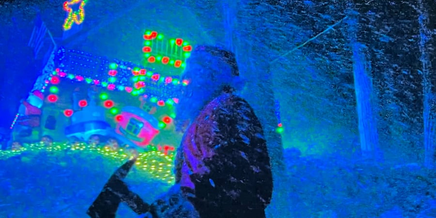 Santa with an axe stalks around a brightly Christmas-lit house