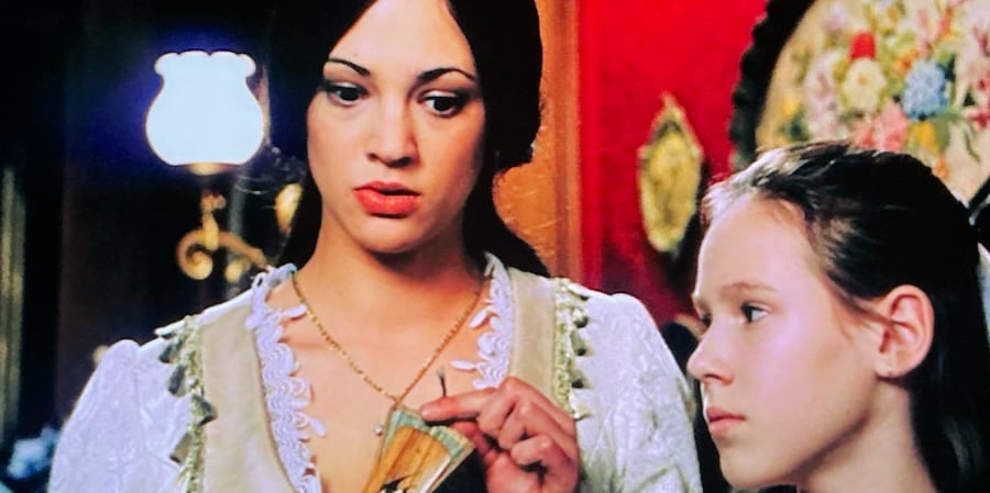 Christine looks confused and fingers a jade fan.