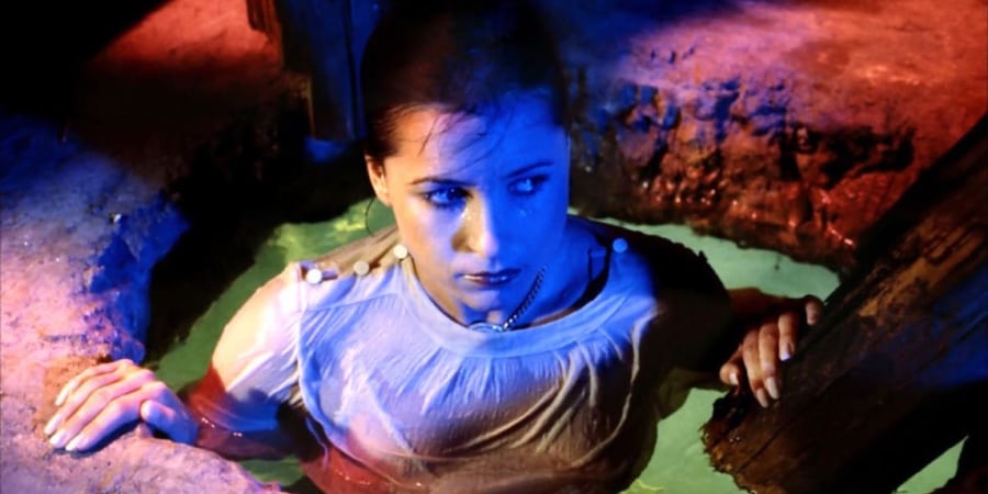 A woman emerges from a colourful pool of water