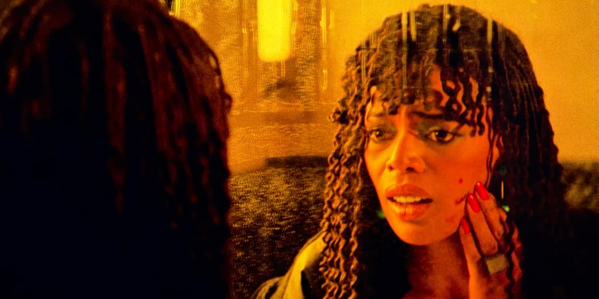 A woman looking worriedly in the mirror at a scratch on her face.