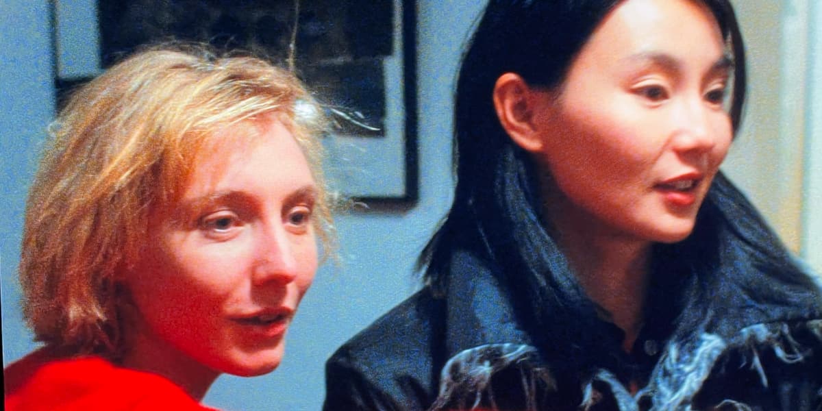 Two woman look smiling at someone off camera.
