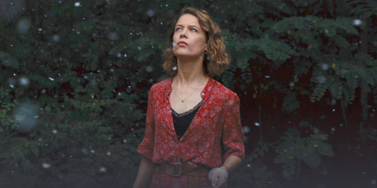A woman standing in falling ash.