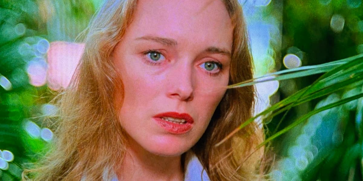 A woman with bushes bwhind looking apprehensive.